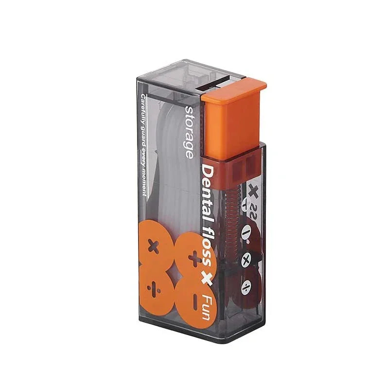 A vertical view of a portable dental floss dispenser case in grey and orange containing white dental floss sticks.