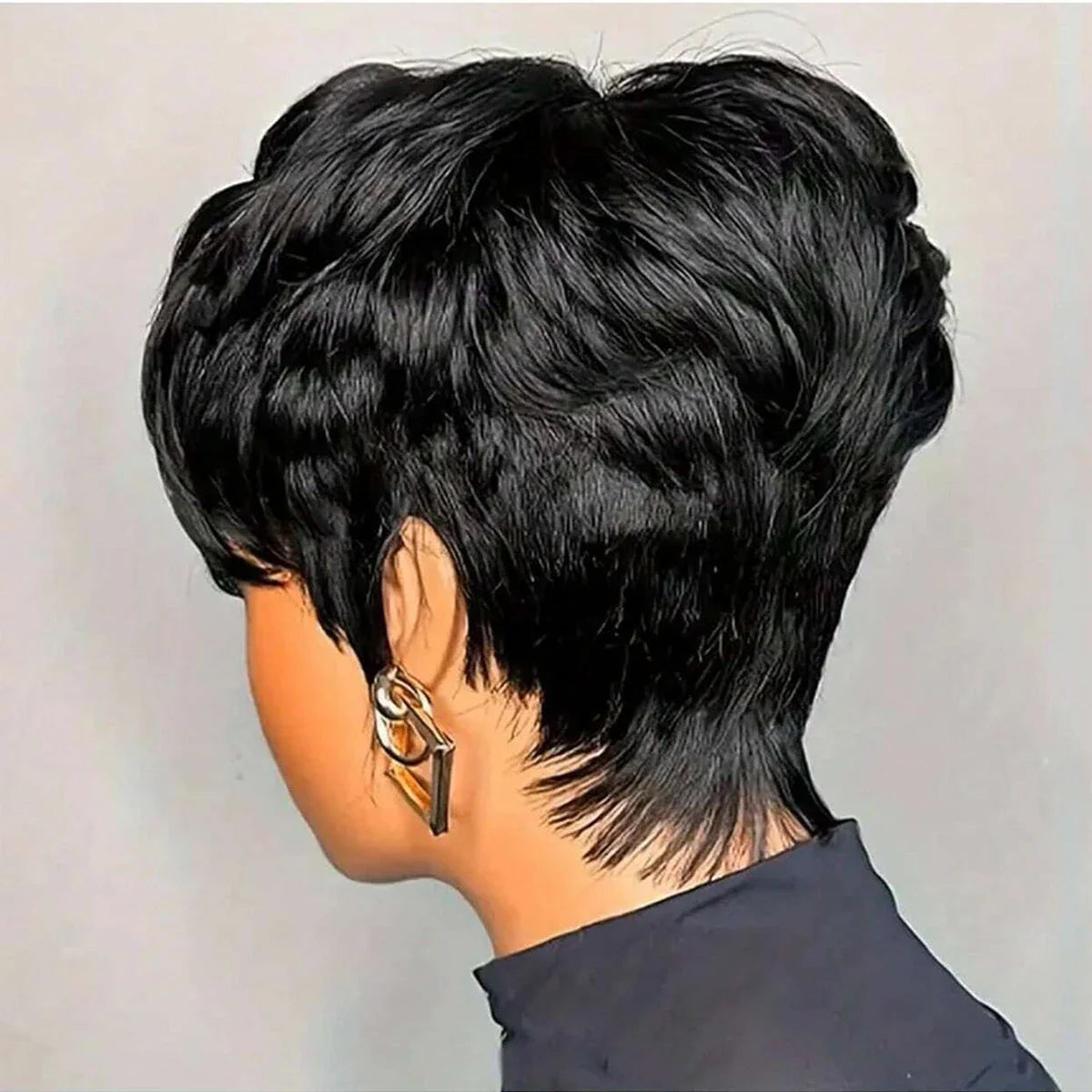 A back view of a woman with a short black layered pixie cut hairstyle.