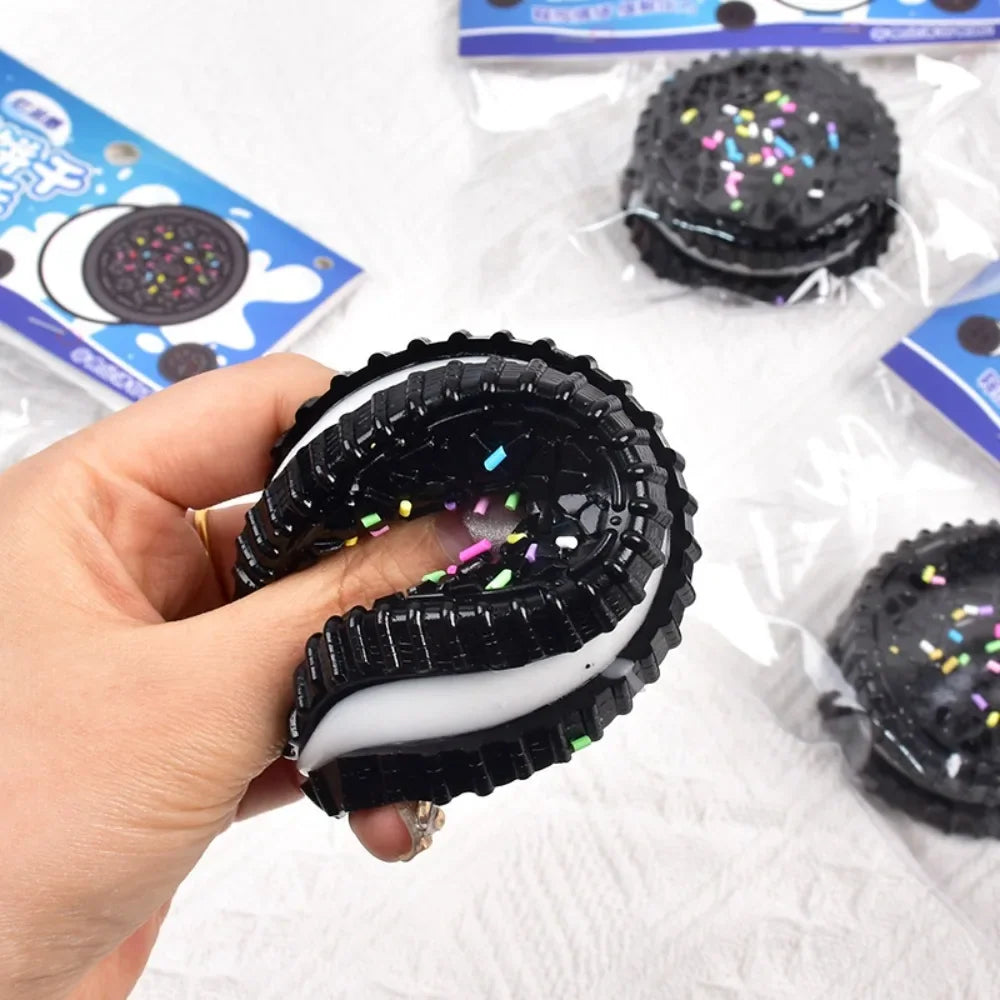 A black and white cookie-shaped stress relief squishy toy being squeezed.