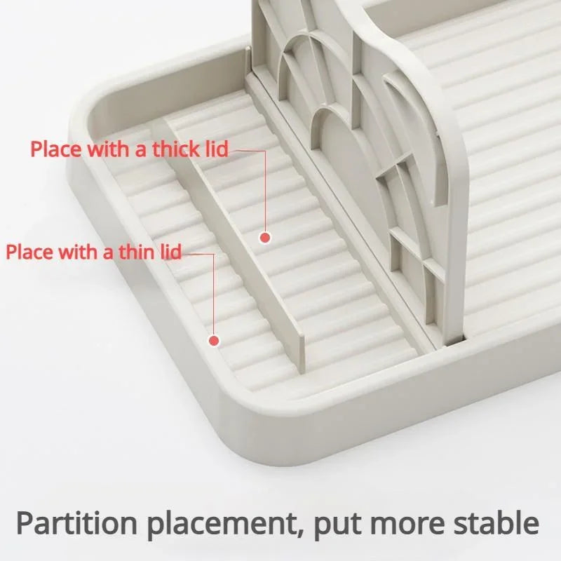 Close up of the adjustable divider on a beige kitchen utensil rest with labels for different lid thicknesses.