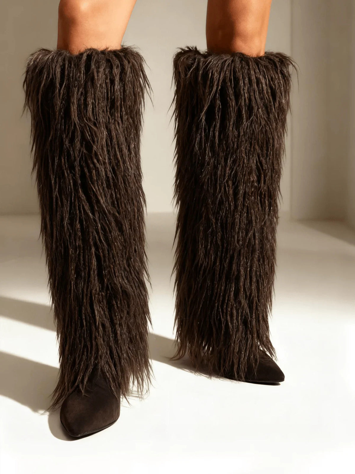 Dark brown faux fur knee high stiletto boots with a pointed toe
