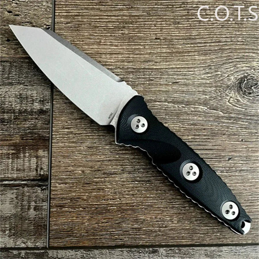 Fixed blade knife with a stonewashed Wharncliffe blade and black handle on a wood grain background.