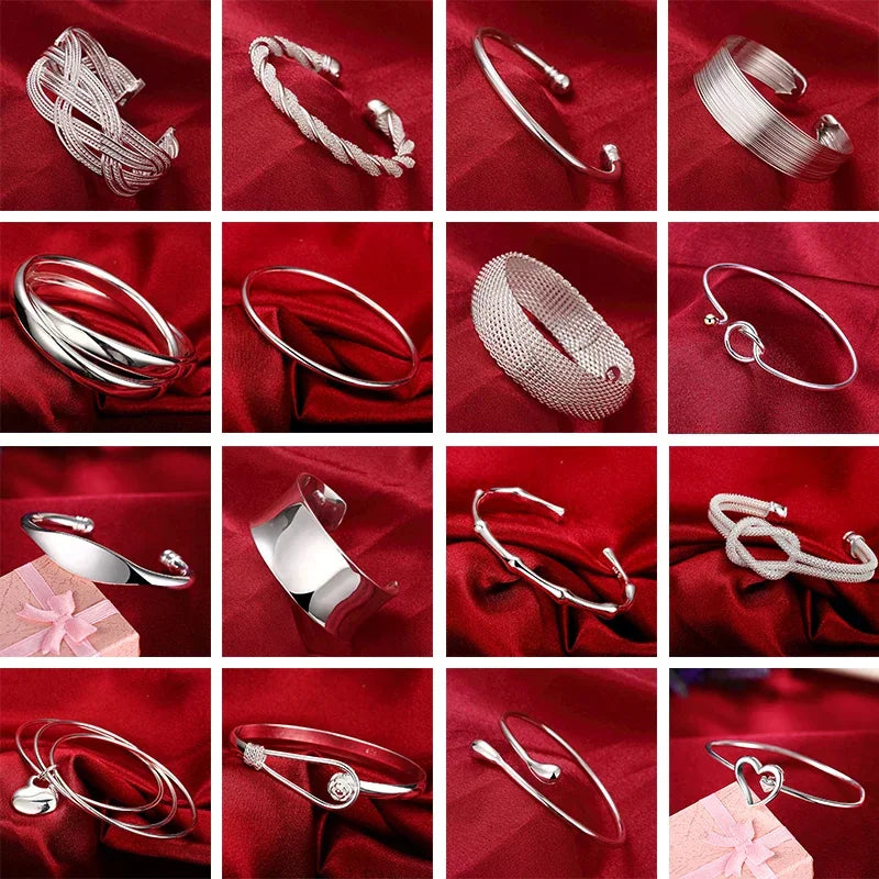 A variety of silver cuff bangles on a red fabric background