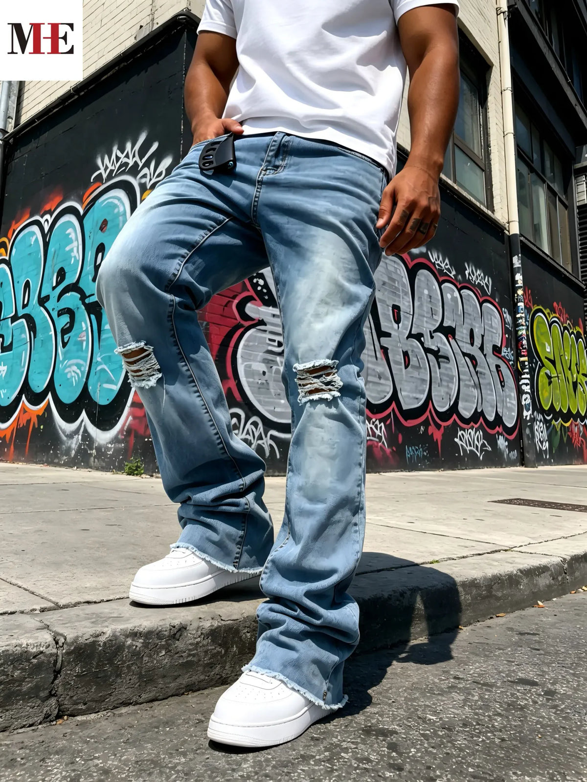 Men's light blue distressed flared jeans with knee rips and frayed hem, worn with white t-shirt and sneakers