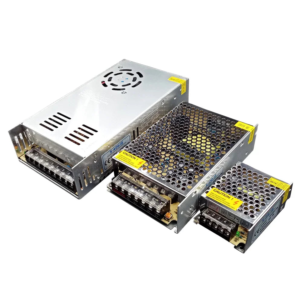 Three different sizes of metal-cased voltage power supply units arranged in a row
