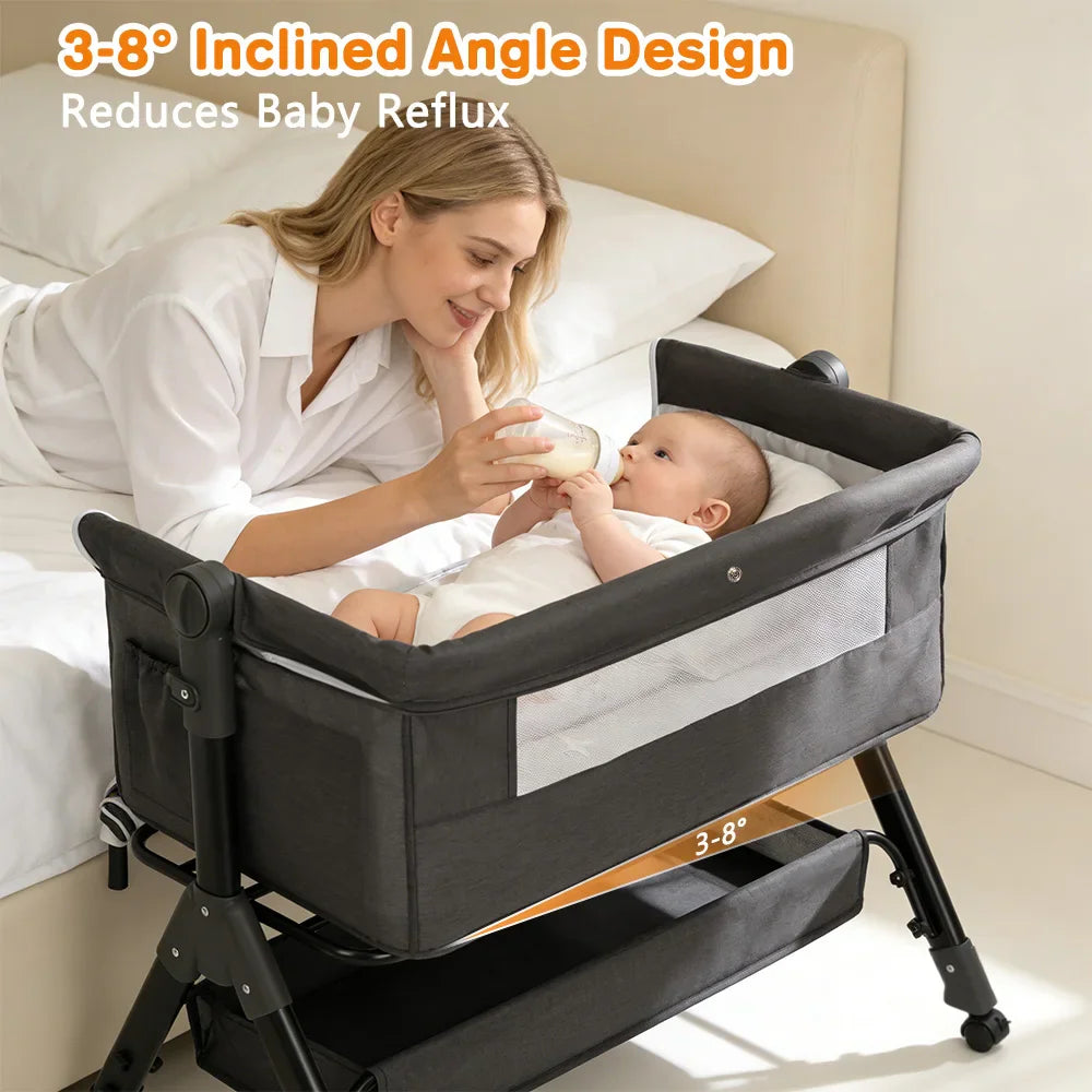 A woman feeding a baby in a grey bassinet with an adjustable 3-8 degree incline angle for reflux.