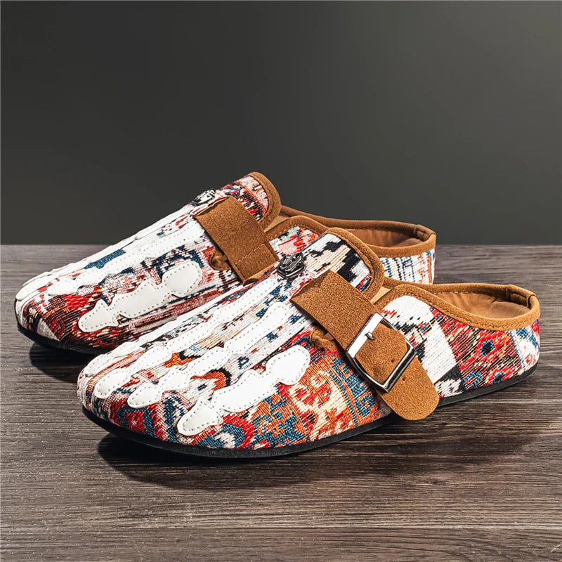 Men's slip-on mule shoes with a colorful patterned fabric and a white skeleton hand design, brown buckle strap