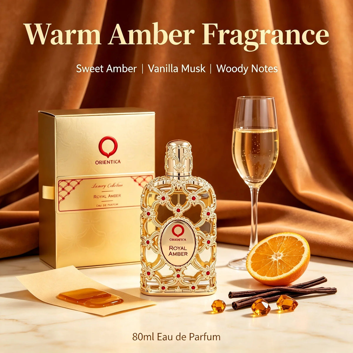 A glass perfume bottle with gold filigree and red stones, next to its gold box, an orange slice, and vanilla pods.