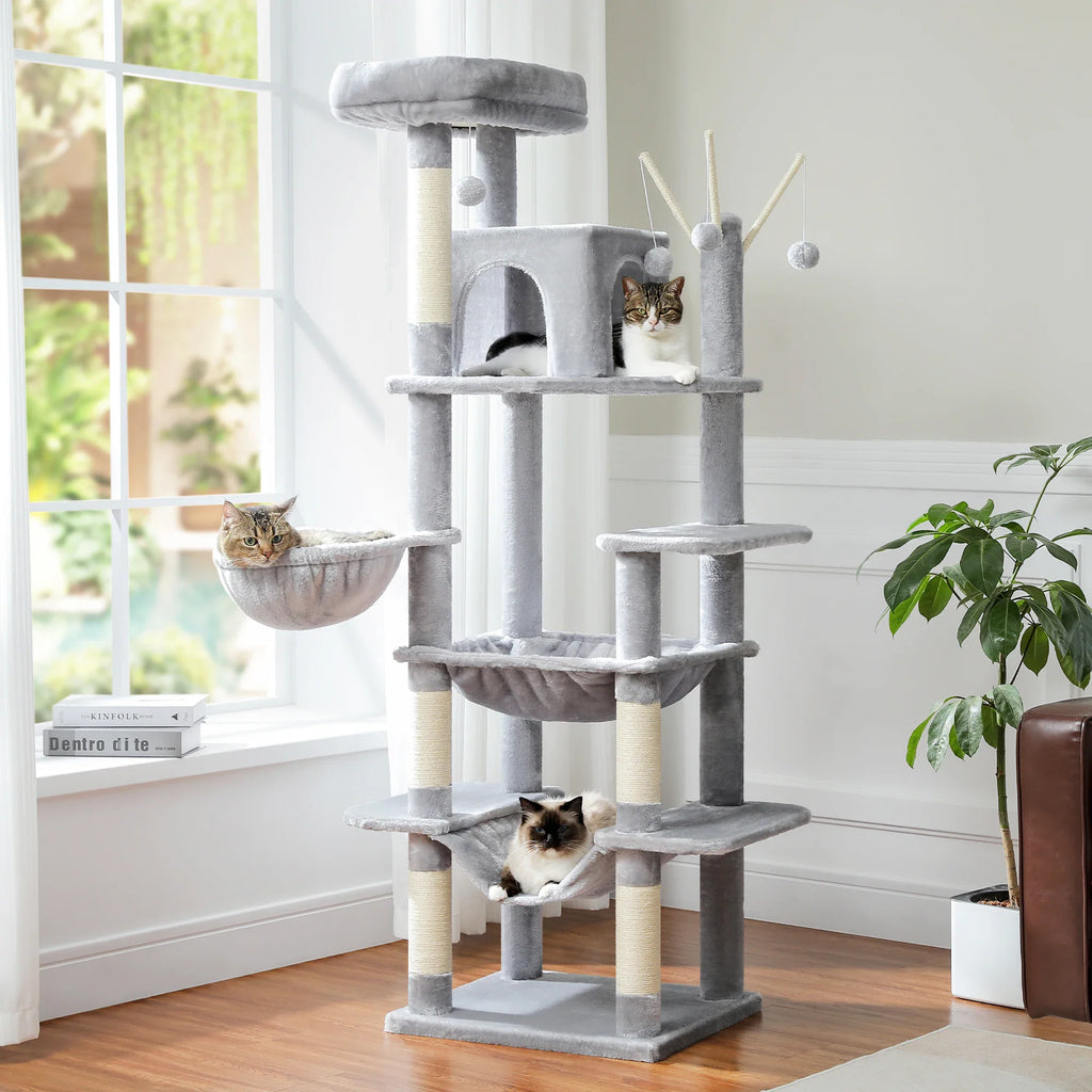 Large multi-level grey plush cat tree tower with hanging toys, perches, and condos with three cats.