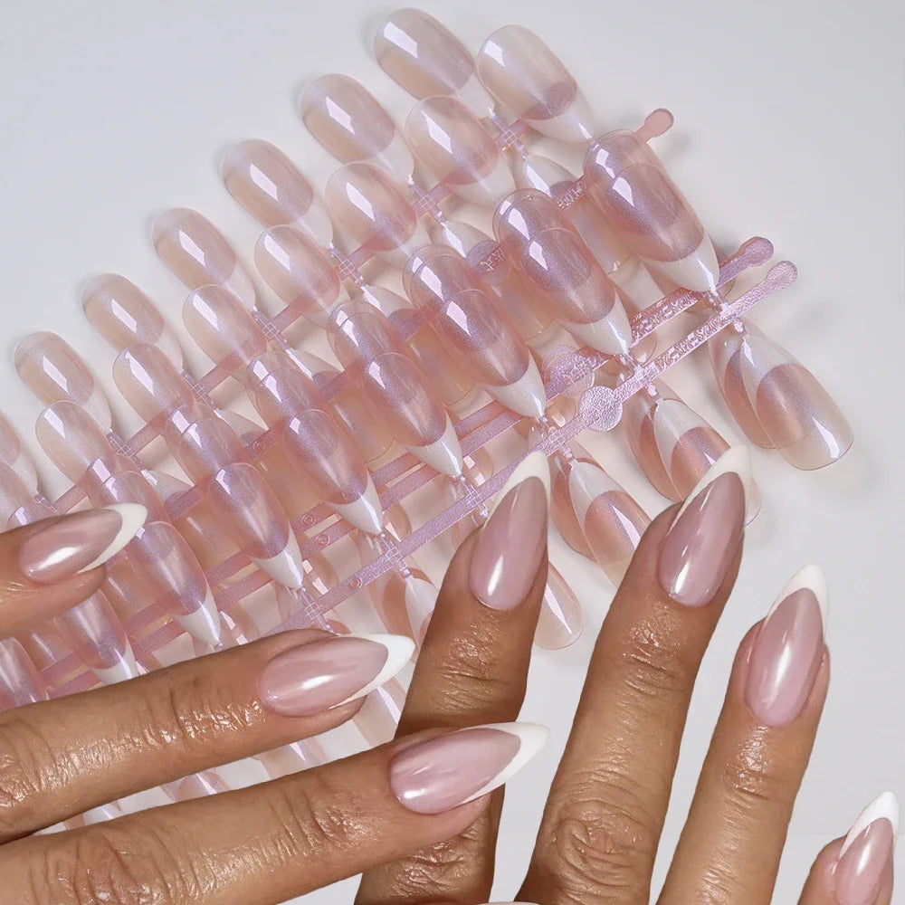 Hand wearing french tip almond-shaped press-on nails with pearlescent finish