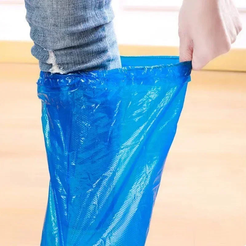 Hand putting on a blue plastic disposable rain shoe cover