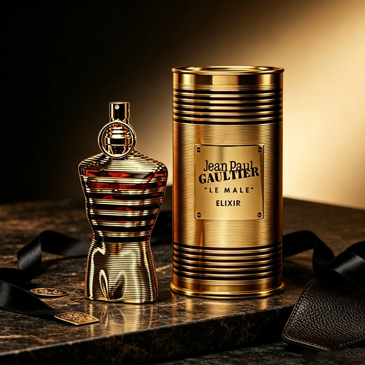 Gold striped male torso shaped perfume bottle and matching gold metal canister on a dark marble surface