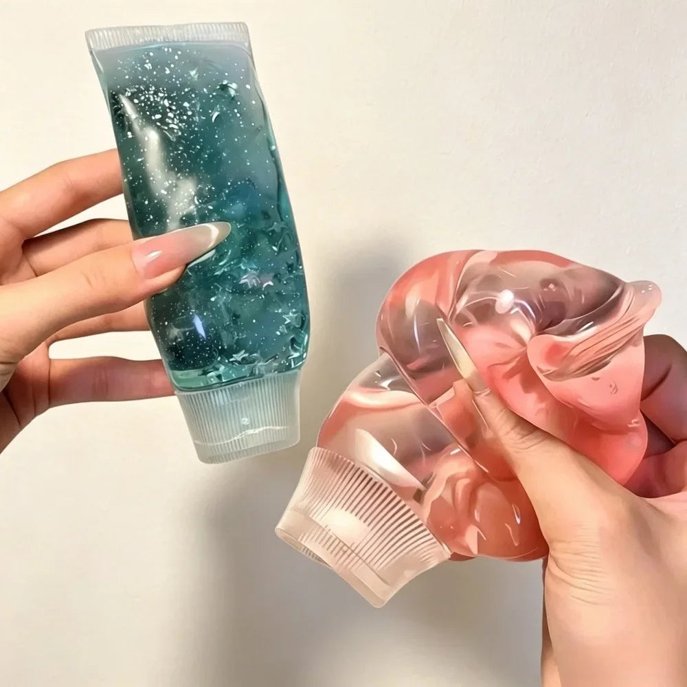 Two hands squeezing squishy gel-filled toothpaste tubes in blue and pink.