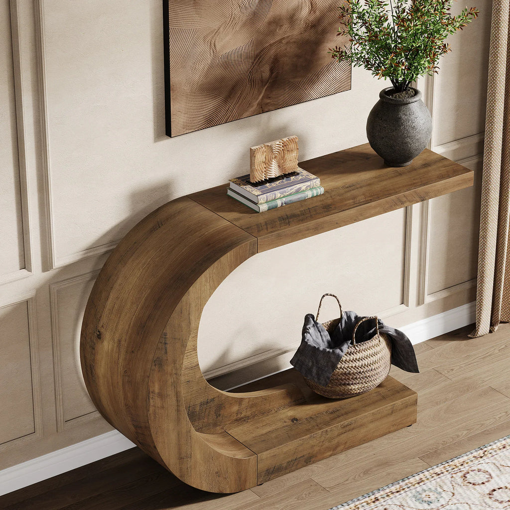 C-shaped wooden accent table in a living room with a plant and basket.
