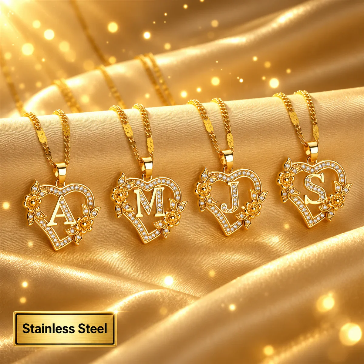 Four gold heart-shaped initial necklaces with floral accents on a shiny fabric background
