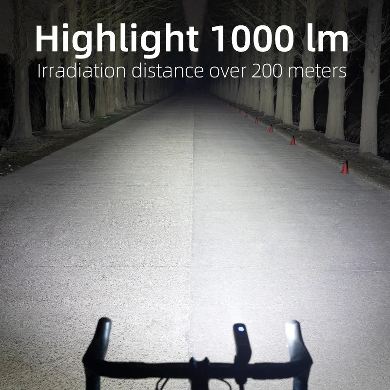 A first-person view from a bicycle handlebar showing the powerful beam of the bike light on a dark path