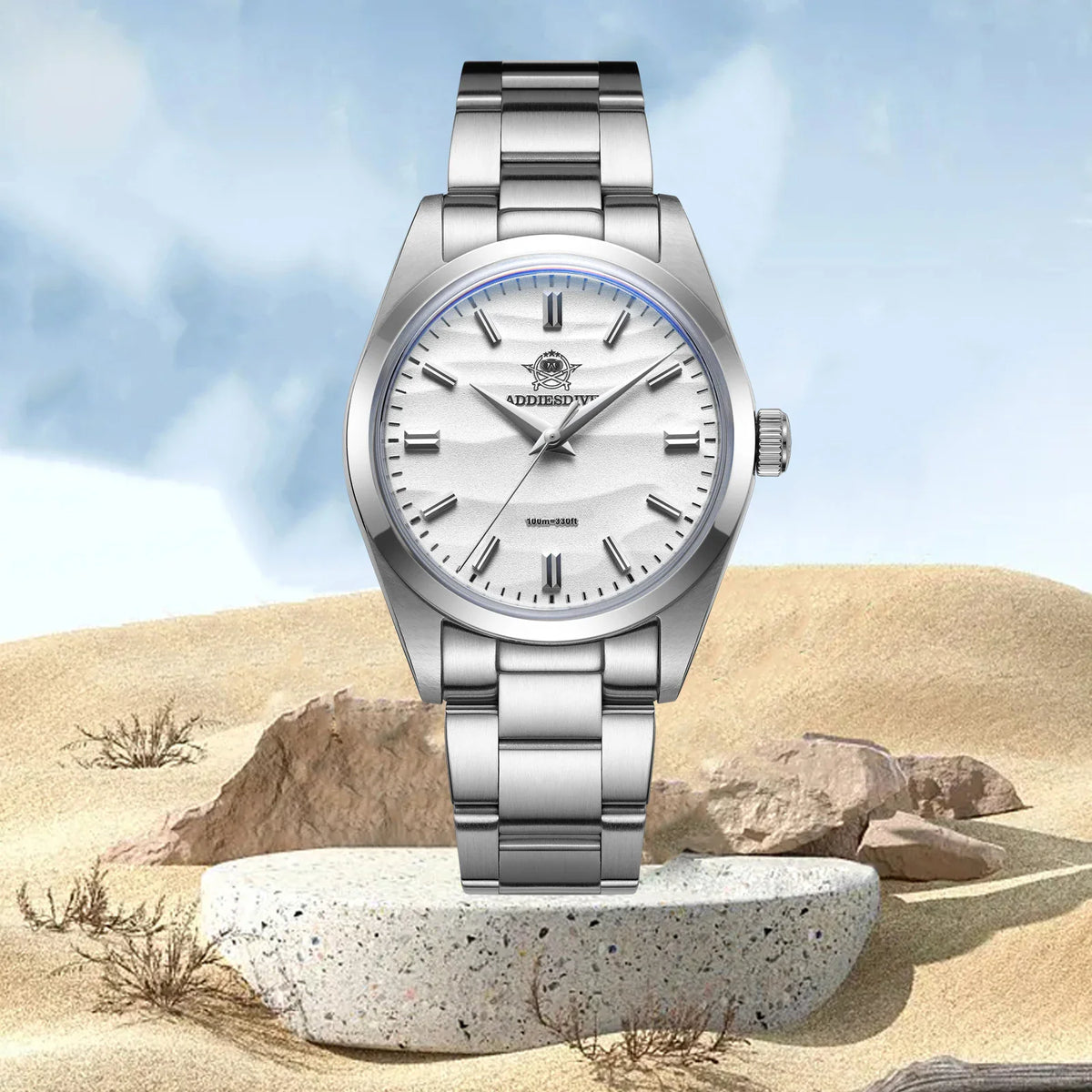 Stainless steel watch with a white dial displayed on a stone platform in a desert landscape