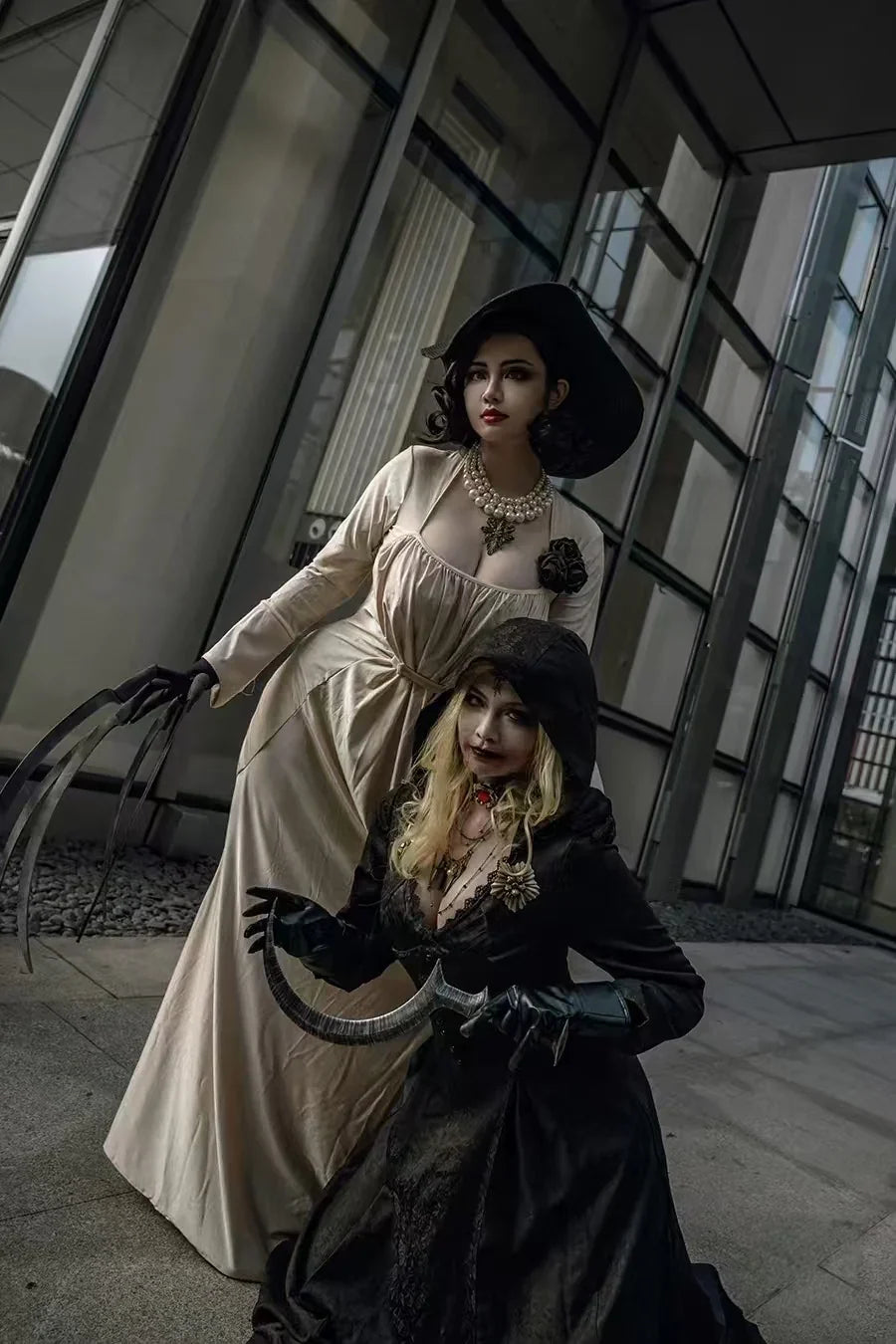 Two women wearing gothic style vampire costumes posing together