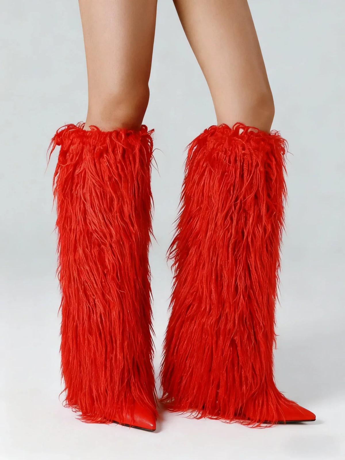 Bright red faux fur knee high stiletto boots with a pointed toe