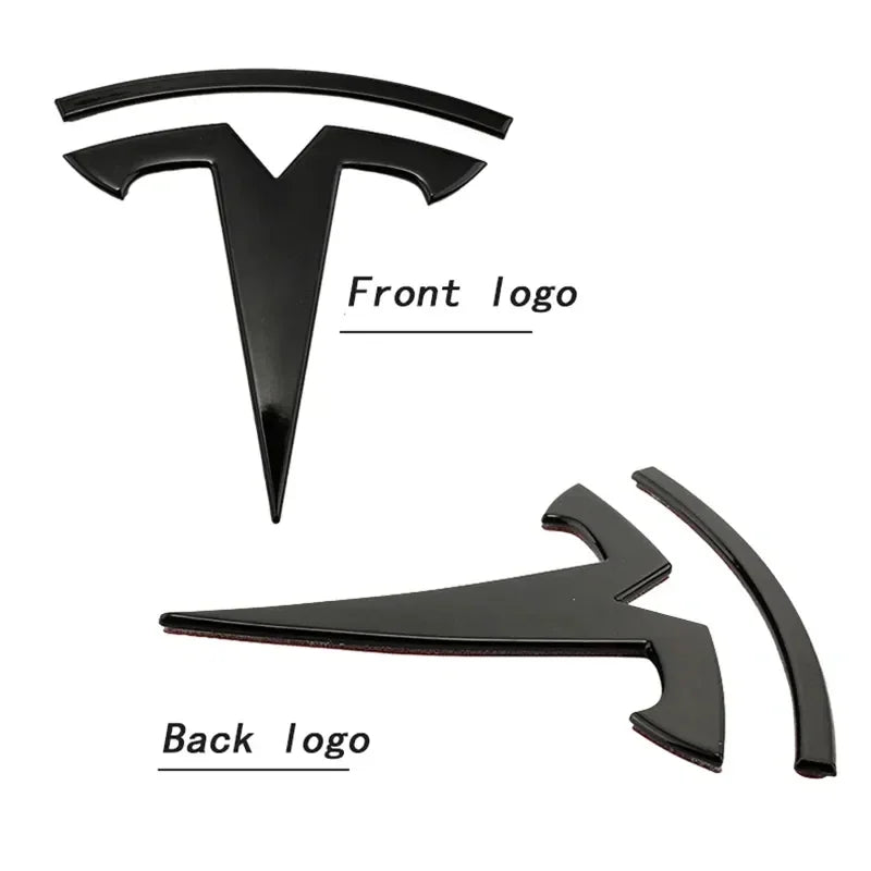 Matte black front and rear vehicle emblems showing adhesive backing