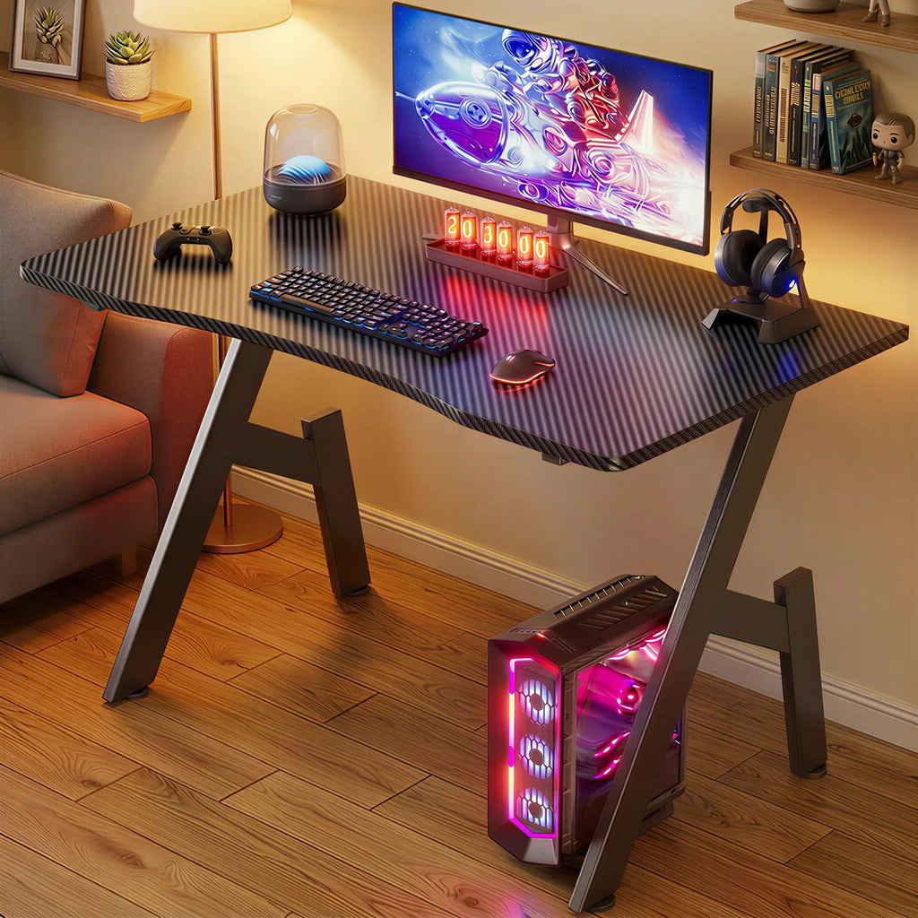 Black carbon fiber gaming desk with desktop computer setup in a living room