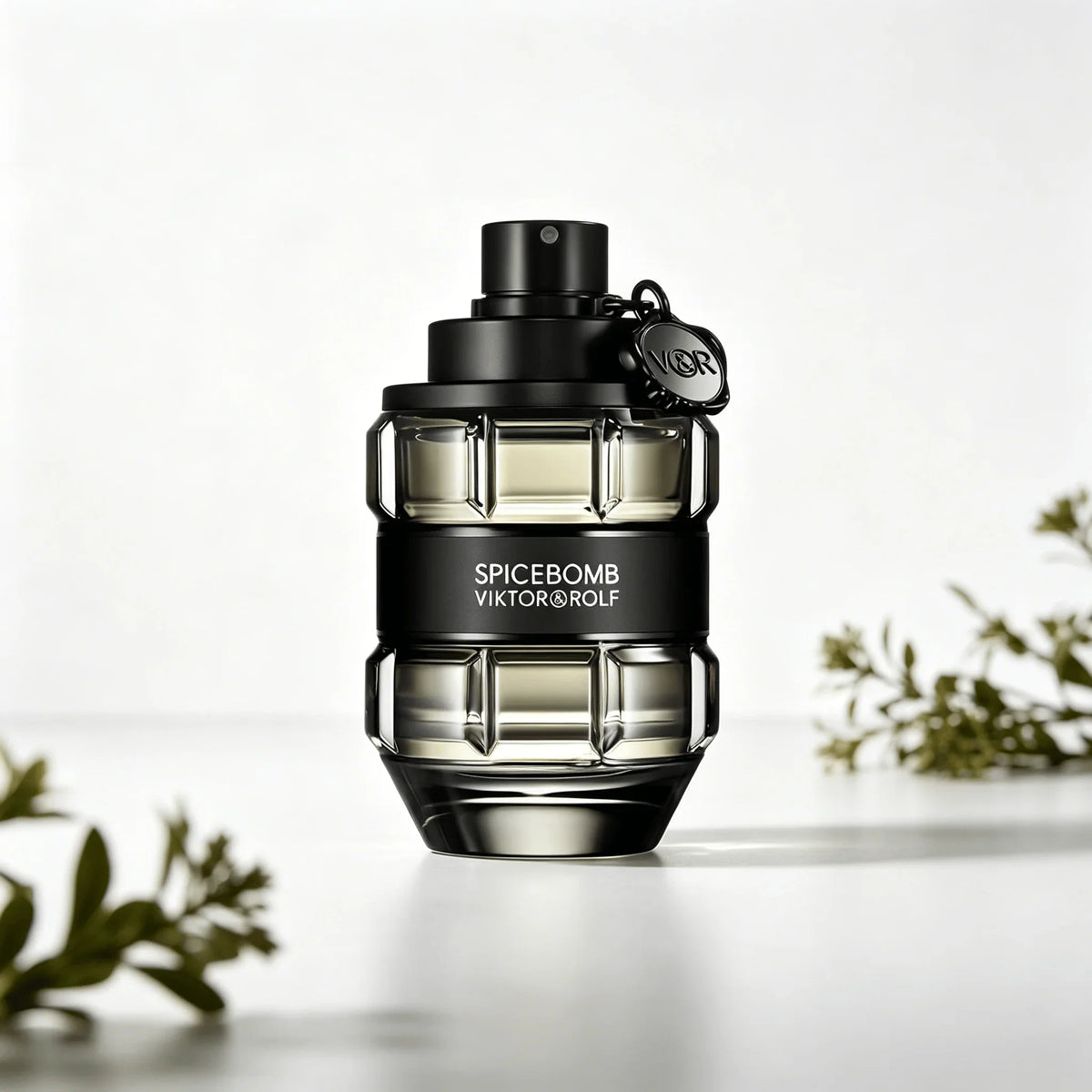 A glass perfume bottle shaped like a grenade, in a transparent black finish with a black band, on a white pedestal with
