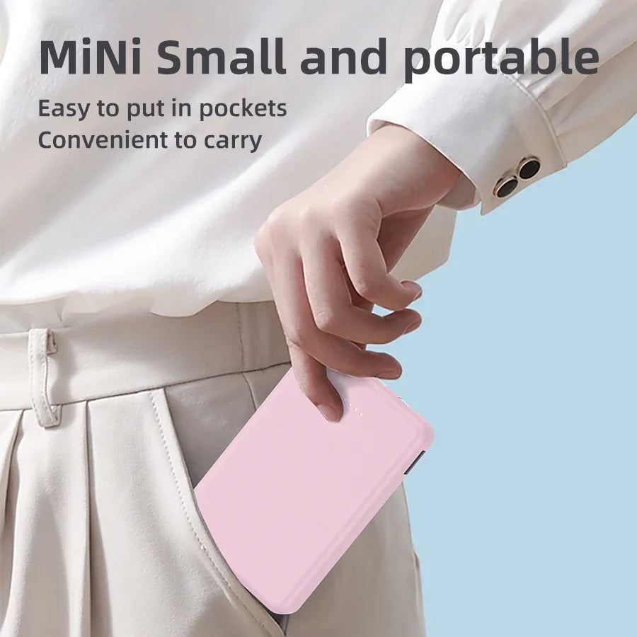 A person holding a small pink power bank in their pocket.