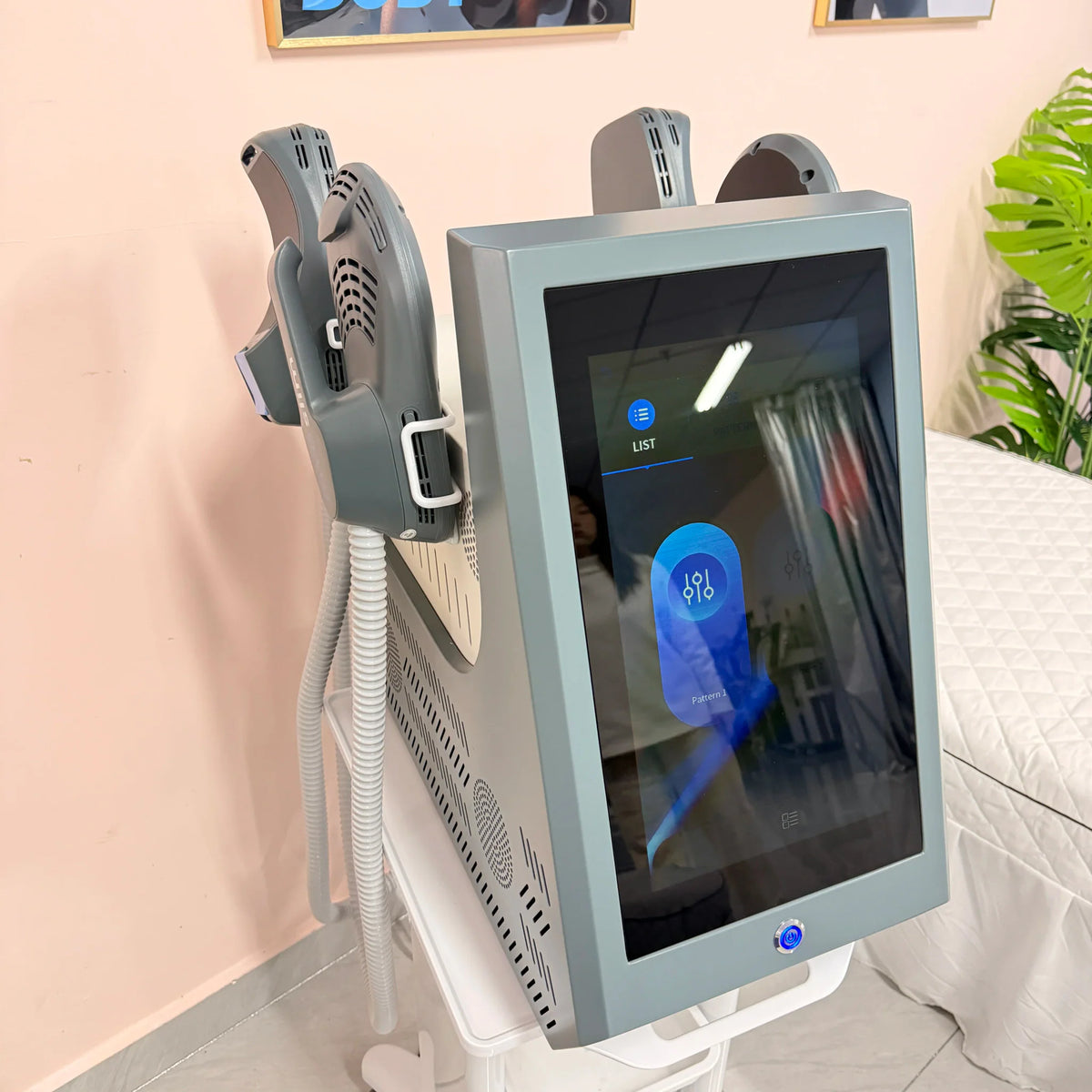 Side view of a professional EMS body sculpting machine with applicators on a stand