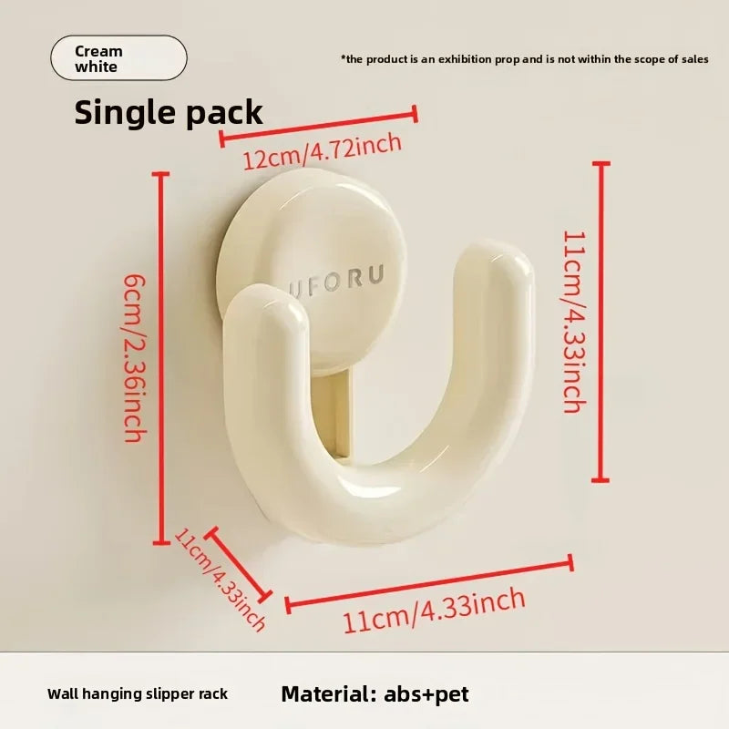 A cream wall-mounted slipper hook with overlaid dimensional measurement text.