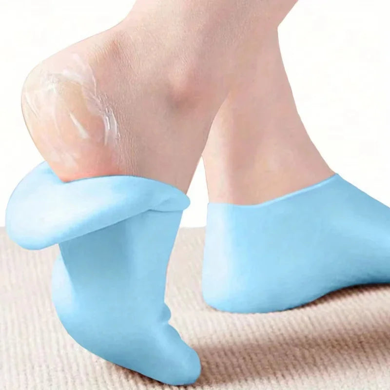 Light blue silicone moisturizing socks worn on feet with lotion
