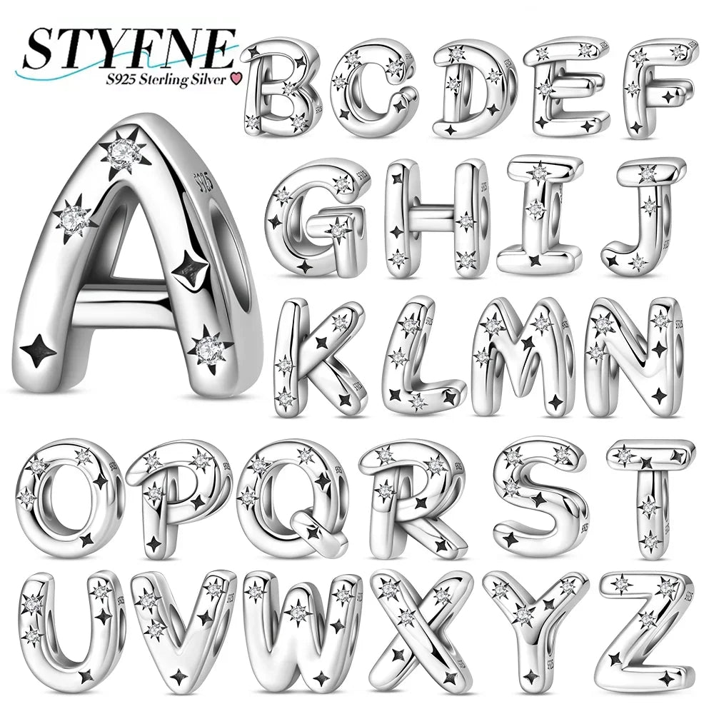 A set of twenty-six sterling silver alphabet charms, each decorated with sparkling stars and small cubic zirconia stones.