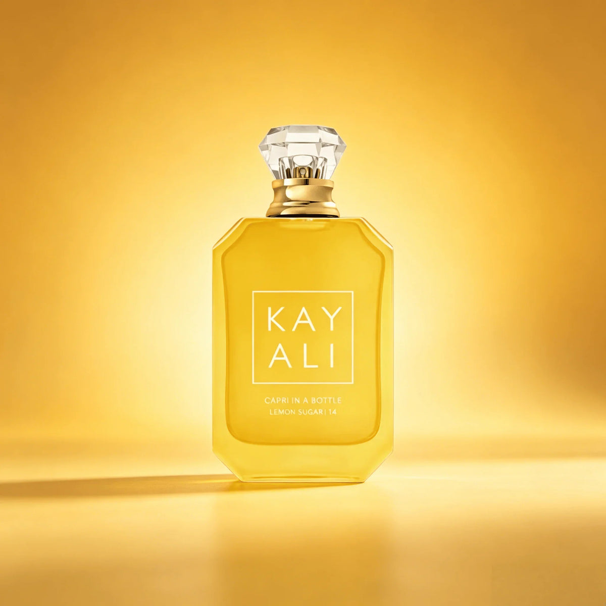 Bottle of lemon sugar scented perfume on a golden yellow background