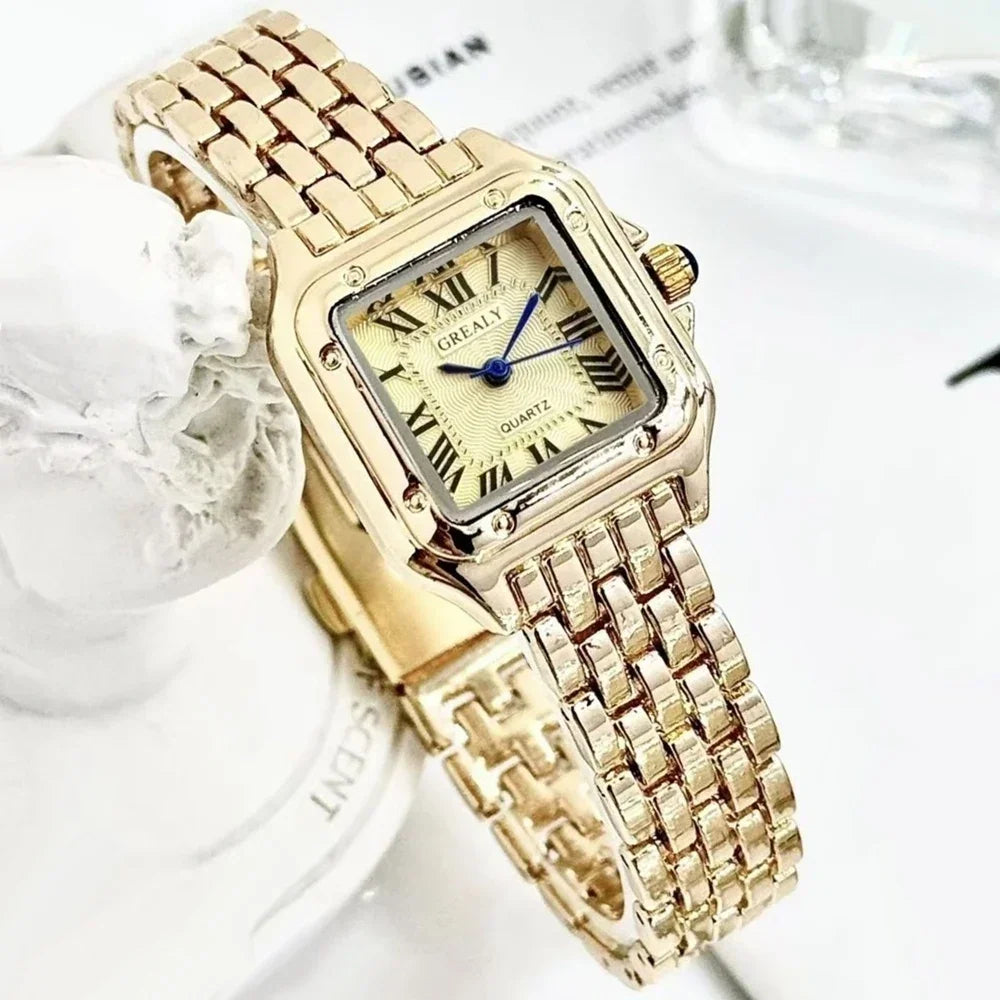 Gold square quartz watch with a textured dial, blue hands, and a gold metal link strap