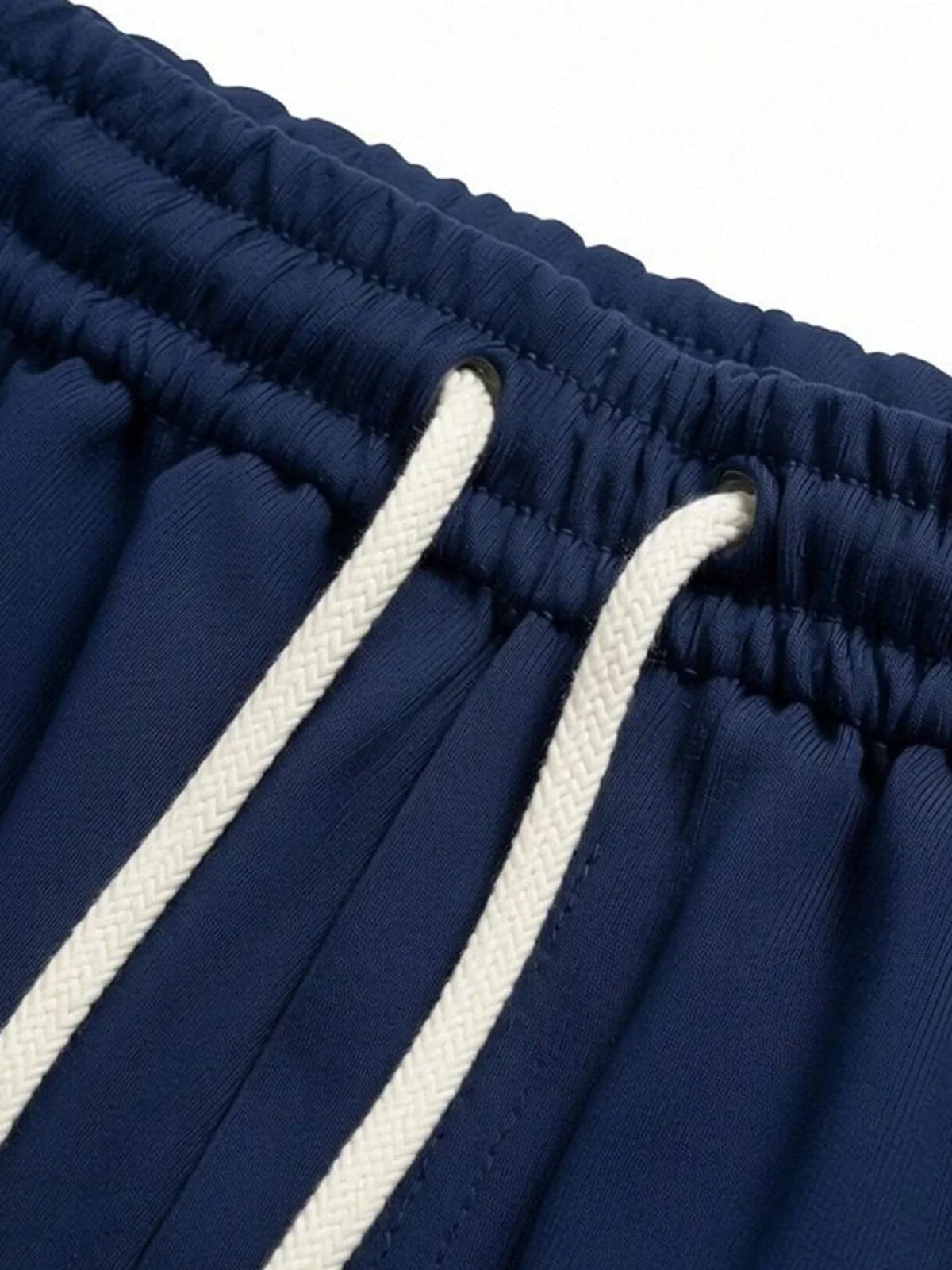 Close-up of the elastic waistband and drawstring on navy blue shorts.