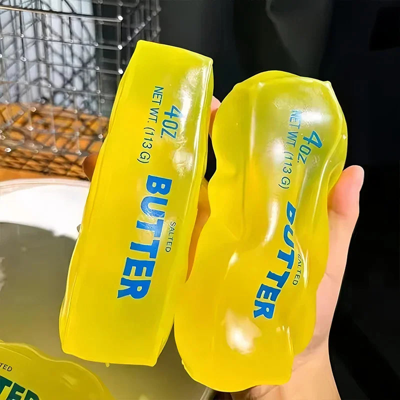 Hand holding two yellow butter stick shaped squishy fidget toys
