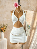 White halter neck mini dress with heart cutout, ruched design, and shell waist chain on a mannequin with accessories
