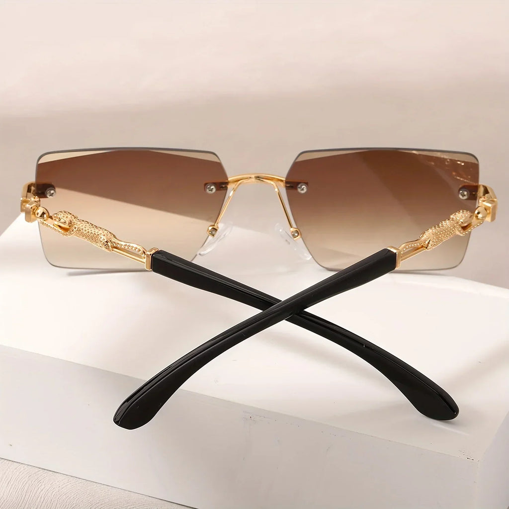 Rimless rectangular sunglasses with brown gradient lenses and gold panther-style metal temples