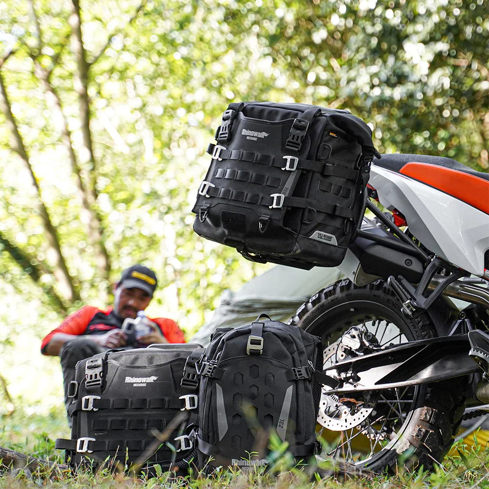 Black waterproof motorcycle side bag mounted on a bike with rider in the background