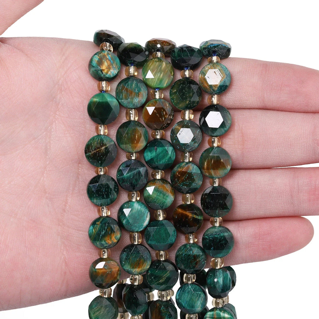 Green tiger eye natural stone faceted coin beads on a palm