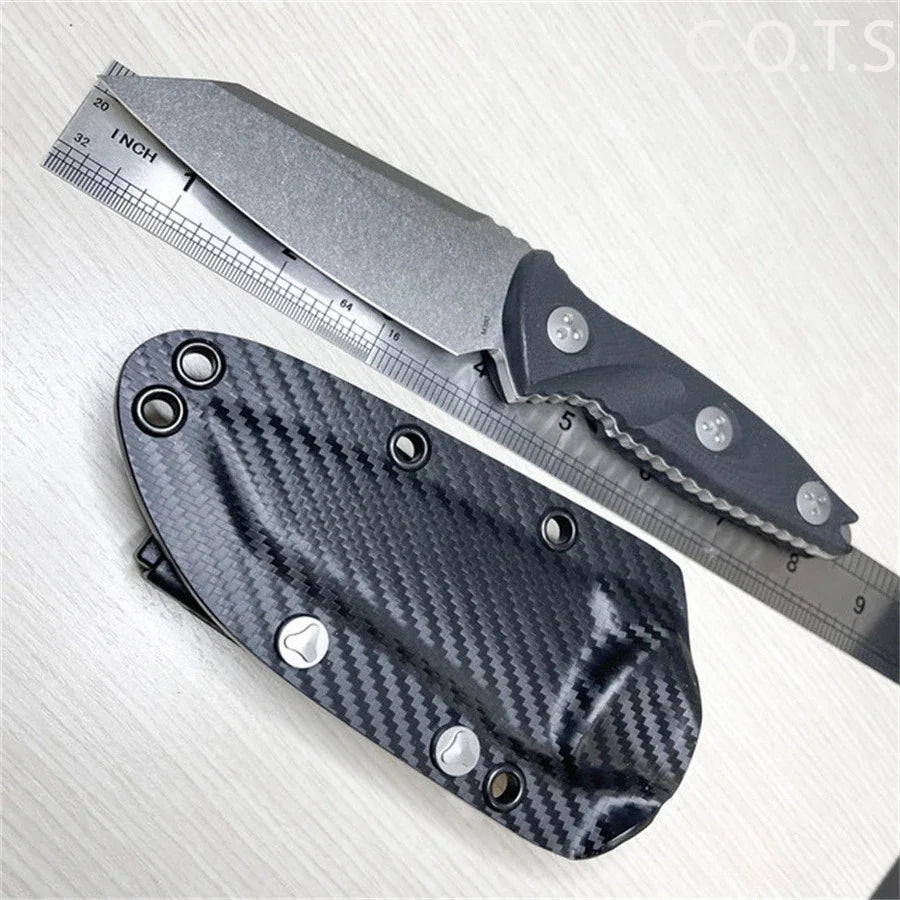 Fixed blade knife being measured with a metal ruler, with its Kydex sheath underneath.