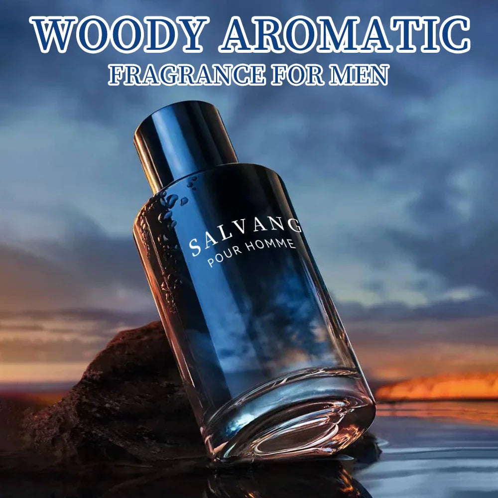 A glass perfume bottle with dark blue gradient placed on a rock by the water