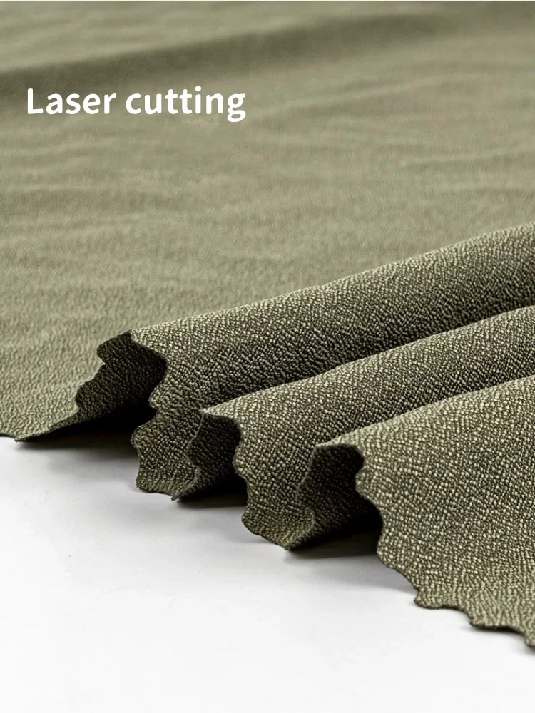 Close-up view of the texture and laser-cut edges of an olive green microfiber towel.