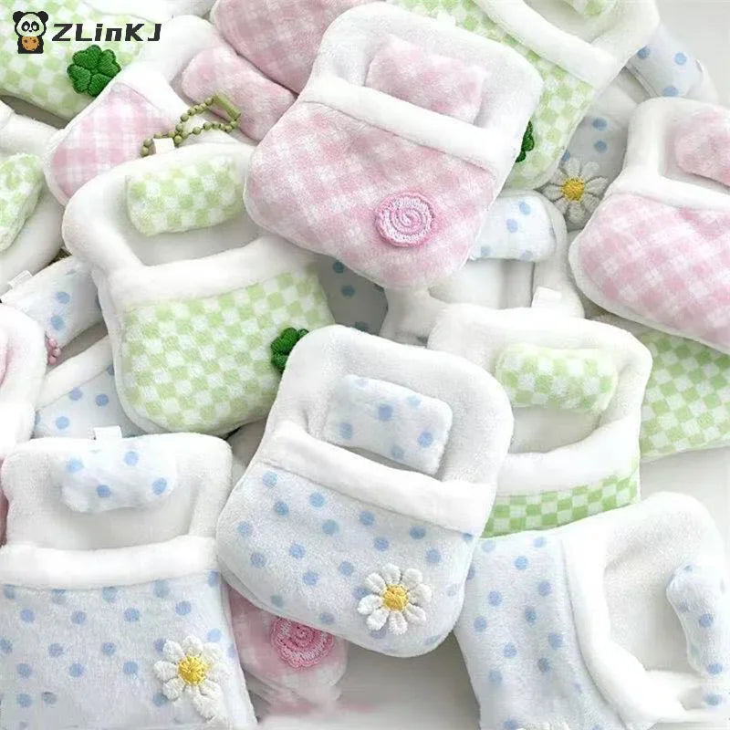 Collection of various miniature plush doll sleeping bags with pillows and floral designs
