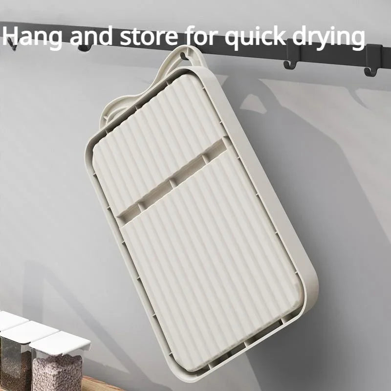 A beige kitchen utensil rest hung on a wall-mounted hook rail for storage.