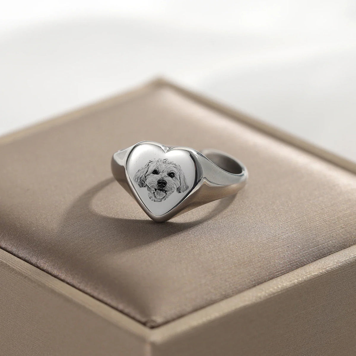 Silver-toned heart signet ring featuring a custom engraved dog portrait on a velvet display cushion