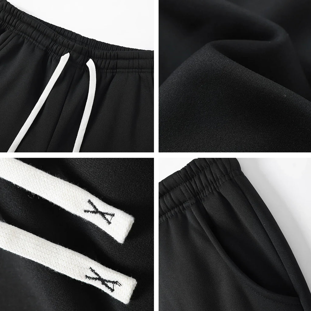 Close-up details of black casual sweatpants including the waistband, fabric texture, and pockets.