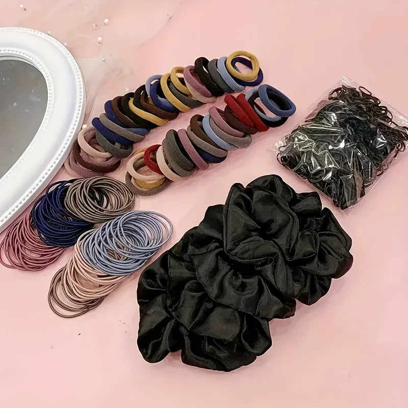 Hair accessory set featuring elastic ponytail holders, fabric scrunchies, and a small plastic hair tool.