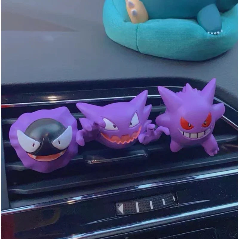 Three different ghost type monster figures attached to a car air vent