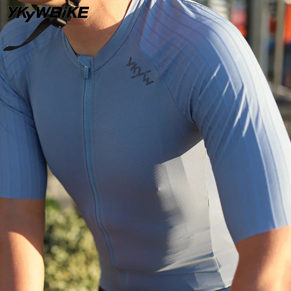 A cyclist wearing a blue short sleeve cycling jersey