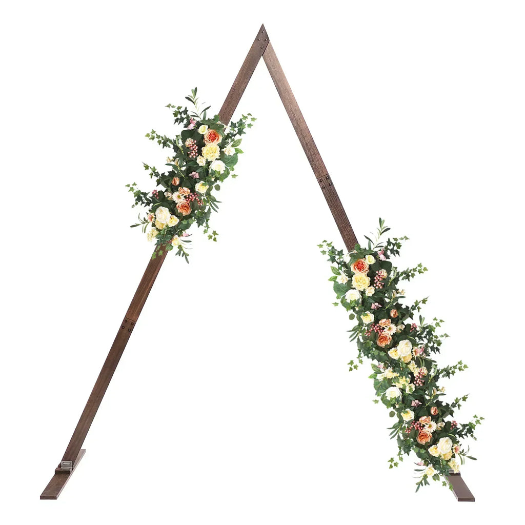 A rustic brown wooden triangular wedding arch frame decorated with lush artificial flowers and greenery.